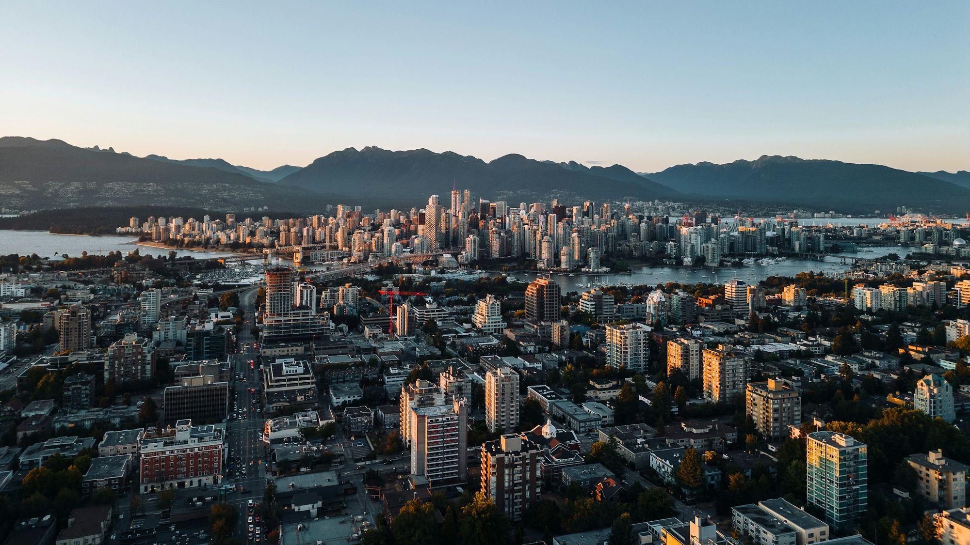 Aerial view north over Vancouver's Broadway corridor to False Creek, downtown and the North Shore mountains at sunset